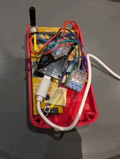 A view of the inside of the Smart Guitar Pedal. There is an ESP32, a potentiometer on the top left, a button on the bottom left, and some wires and connectors between them.